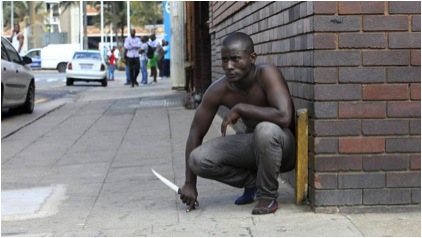 Un homme avec un couteau dans les rues de Durban, le 14 avril. | Photo AFP.