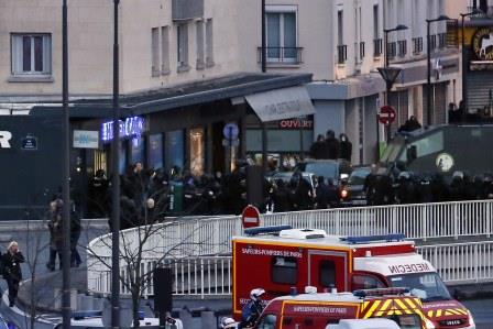 Members of the French police special forces launch the assault at a kosher grocery store in Porte de Vincennes, eastern Paris, on January 9, 2015 where at least two people were shot dead on January 9 during a hostage-taking drama at a Jewish supermarket in eastern Paris, and five people were being held, official sources told AFP. AFP PHOTO / THOMAS SAMSON