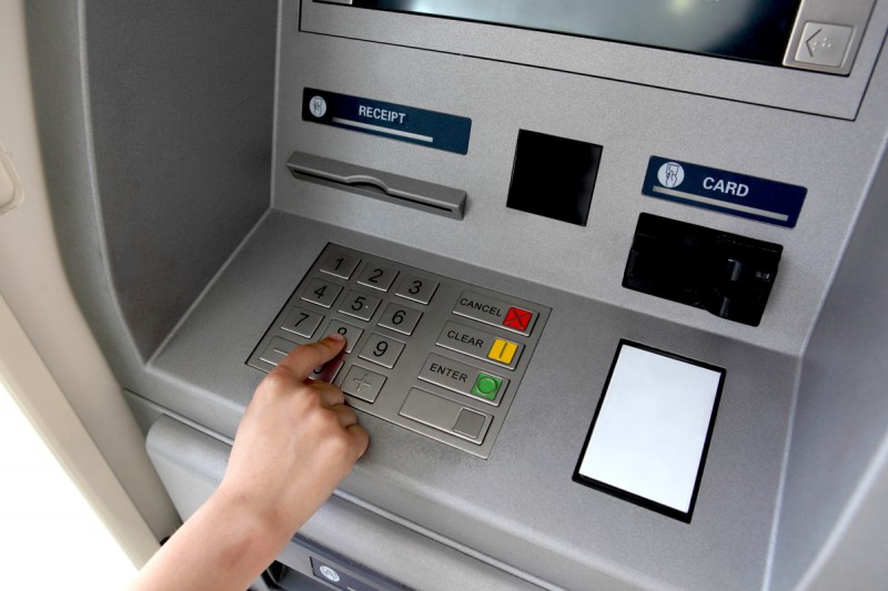 A woman's hand using a cash machine (ATM)
