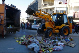 Des hommes détruisent des marchandises qu'ils estiment non conformes. Reuters/Nour Forat