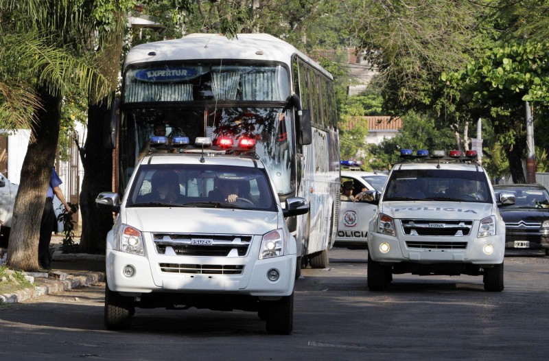 Fans of Argentina's Colon de Santa Fe are driven in a bus while escorted by Paraguayan police as they are expelled from Paraguay for vandalism, in Asuncion