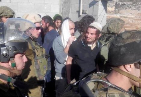 Meir Ettinger, portant une kippa blanche, est escorté par des soldats de Tsahal dans le village palestinien de Qousra, le 7 janvier 2014. Crédit photo : Rabbins pour les Droits de l’Homme.