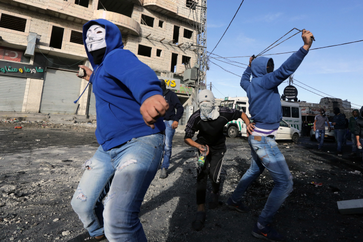 Des palestiniens en train de lancer des pierres contre les forces de l’ordre israéliennes.  Crédit photo: Sliman Khader/Flash90