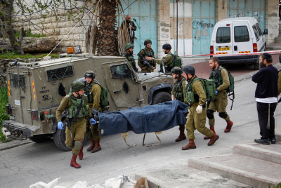 Des soldats évacuent le corps d’un des deux Palestiniens qui ont poignardé jeudi matin un soldat à Hébron Crédit: Wissam Hashlamon/Flash90