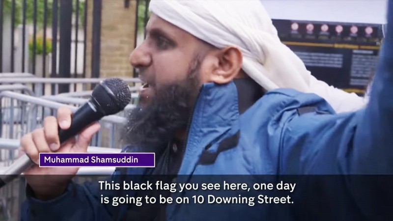 Muhammad Shamsuddin, un islamiste londonien de 39 ans, a été filmé dans un documentaire intitulé « Les Djihadistes du coin de la rue ». Shamsuddin, divorcé et père de cinq enfants vit des aides publiques et affirme qu'il est dans l'incapacité de travailler en raison d'un « syndrome de fatigue chronique ». Il a été filmé en train de prêcher la haine contre les non-musulmans dans les rues en Grande Bretagne. (Image source: Channel 4 video screenshot)
