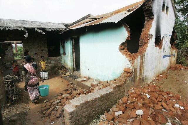 Une famille chrétienne indienne retourne dans sa maison endommagée lors des émeutes par des militants hindous extrémistes dans le village de Bujulimendi dans le district de Kandhamal en Orissa, à environ 350 km au sud-ouest de Bhubaneswar, le 23 octobre 2008.